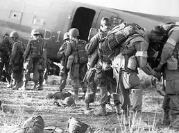 Photo of soldiers walking up to a plane with bags