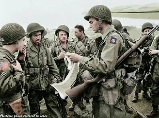 Photo of a soldier explaining something to other soldiers with something in his hand perhaps it is a map
